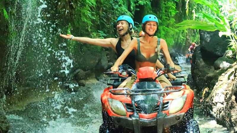 Tourists riding quad bikes through forested trails in Ba Vi National Park