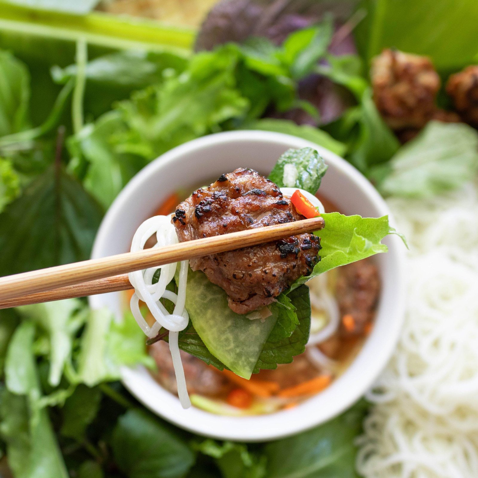 Traditional Bun Cha dish with grilled pork, noodles, herbs and dipping sauce