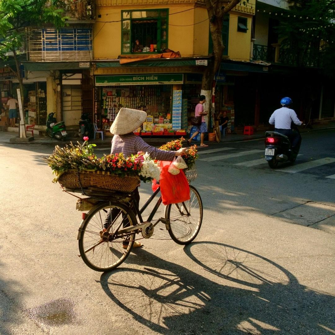 Cyclists taking photos in Hanoi French Quarter with colonial buildings