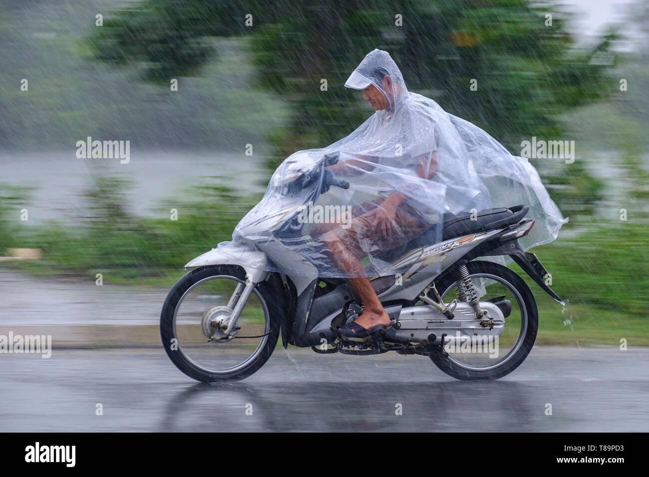Motorbike riders in Hanoi wearing rain ponchos during wet weather