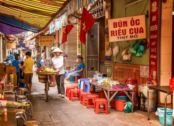 Vibrant street food stalls in Hanoi with locals enjoying traditional dishes