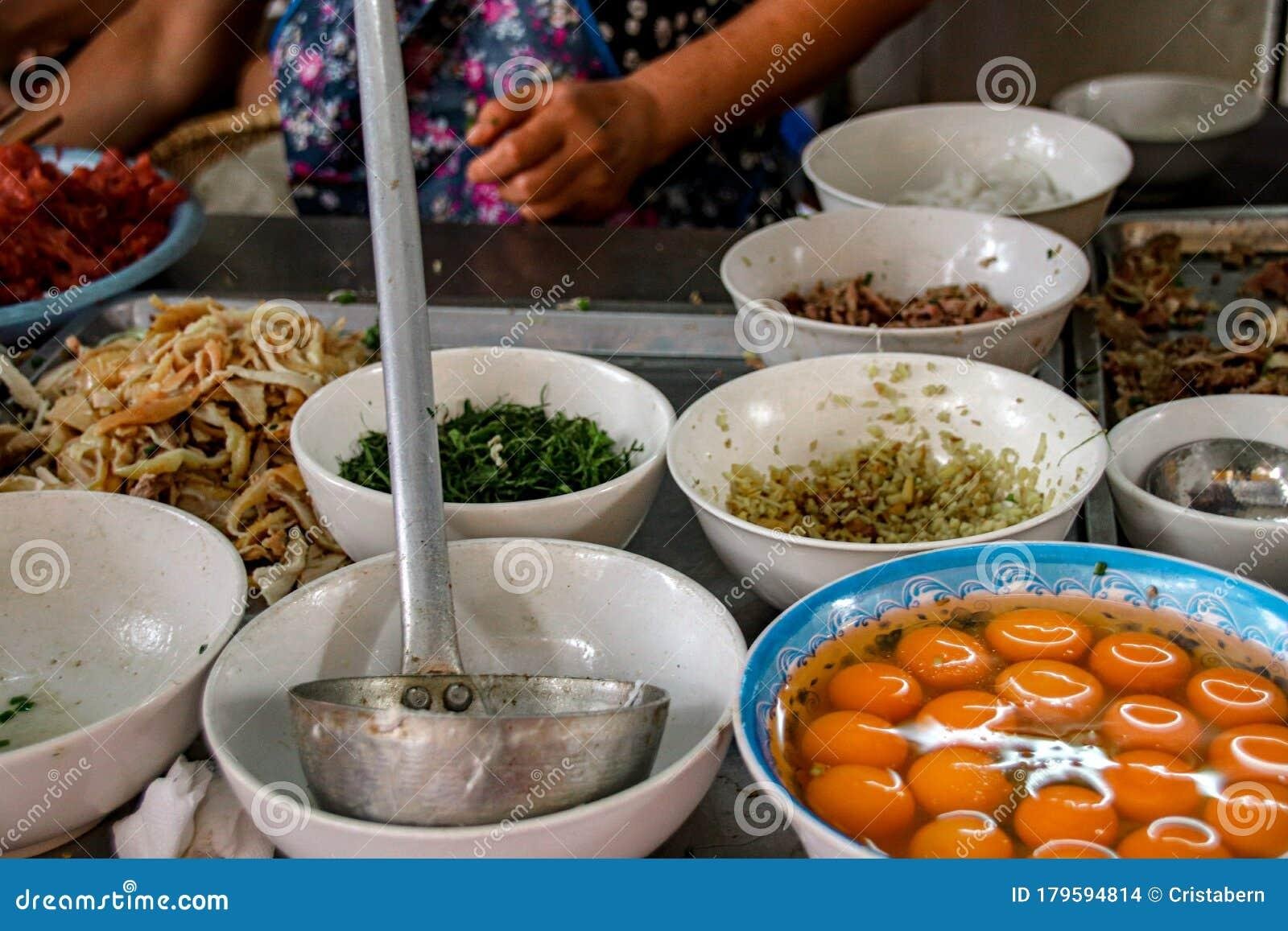 Street food vendor preparing traditional Vietnamese dish in Hanoi