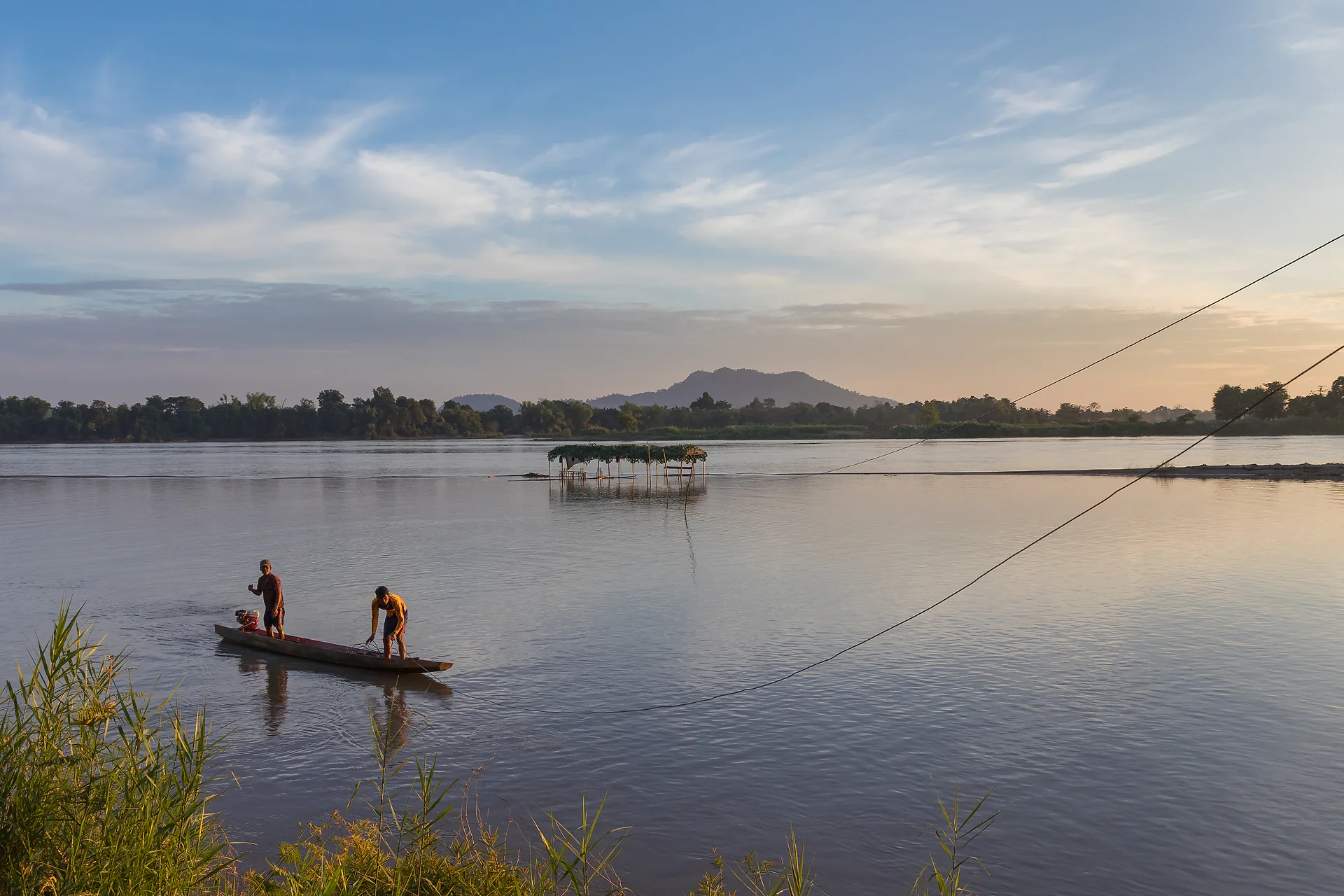 Group of travelers enjoying a Mekong river sunset together
