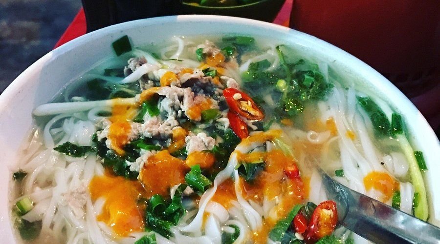 Steaming bowl of authentic Hanoi pho bo with herbs and lime