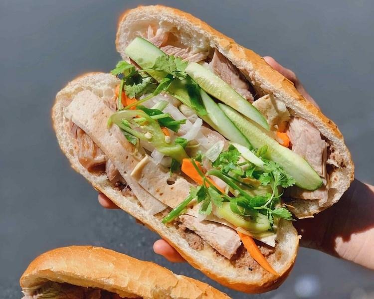 A traditional banh mi vendor preparing sandwiches in Hanoi Old Quarter