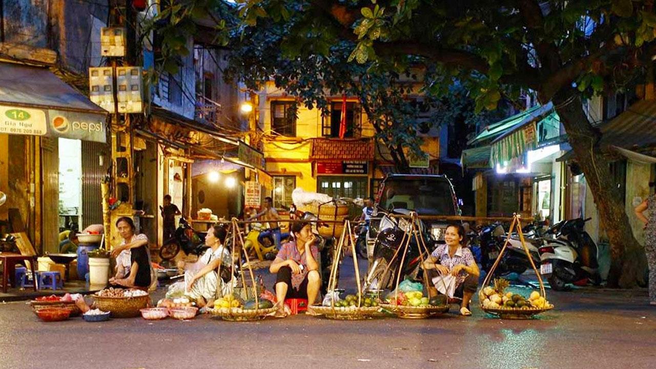 Tourists bargaining with local vendors in Hanoi Old Quarter