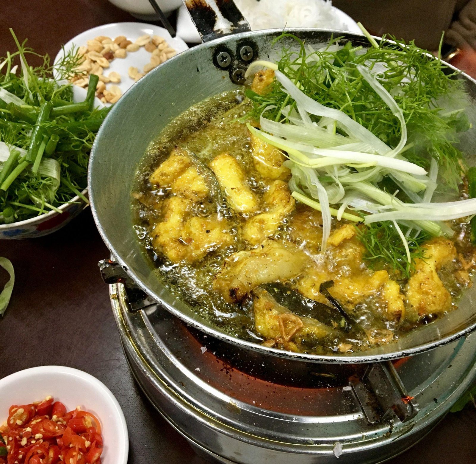 Traditional Cha Ca dish being prepared at a restaurant in Hanoi Old Quarter