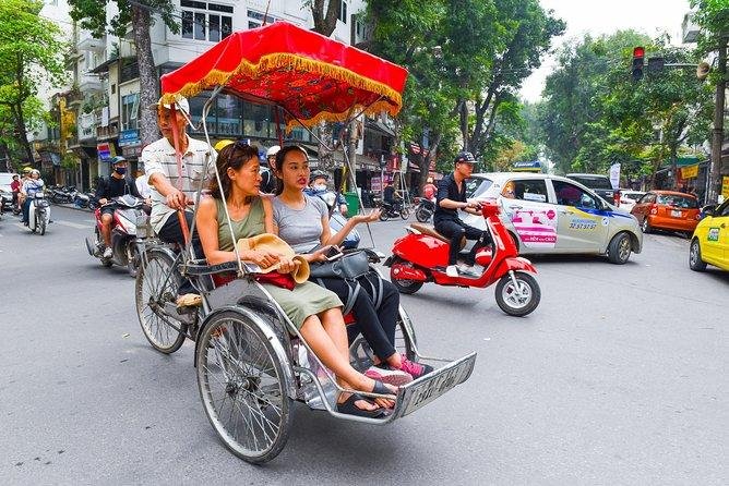 Tourist enjoying a traditional cyclo ride through the streets of Hanoi Old Quarter