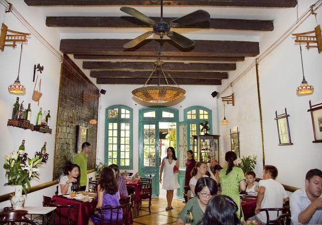 Interior of Green Tangerine restaurant showing elegant French colonial architecture and romantic table settings