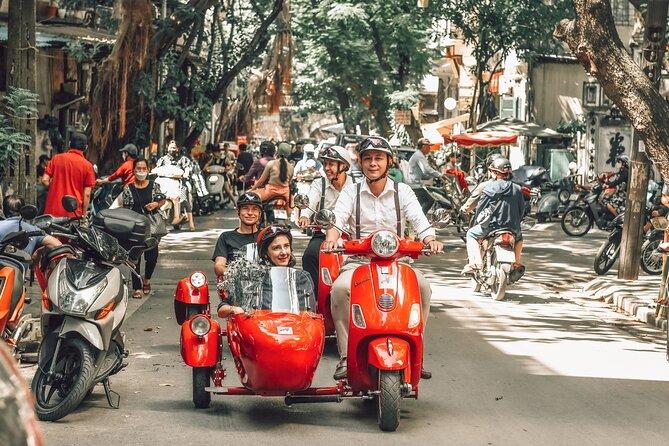 Group of tourists enjoying vespa food tour in Hanoi old quarter