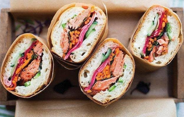 Hanoi banh mi vendor preparing sandwiches for YouTube food tour