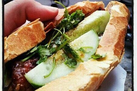 Street vendor preparing fresh banh mi sandwiches with various fillings