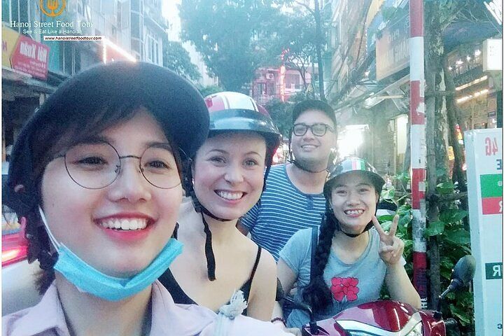 Cyclists enjoying street food in Hanoi Old Quarter