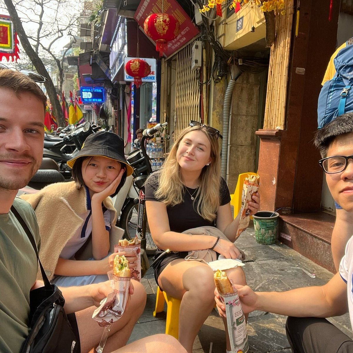 Happy tourists enjoying Vietnamese food with local guides