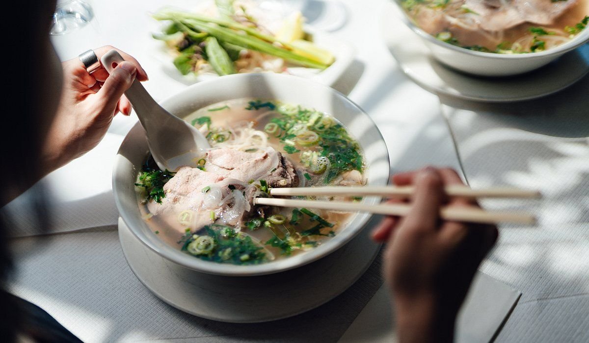 Local food guide explaining Vietnamese dishes to tourists
