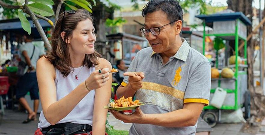 Tour guide explaining Vietnamese food to tourists in Hanoi Old Quarter