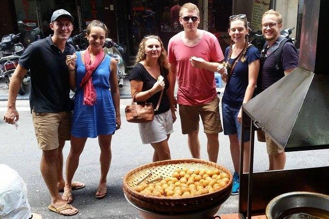 Food tour group enjoying street food specialties in Hanoi Old Quarter