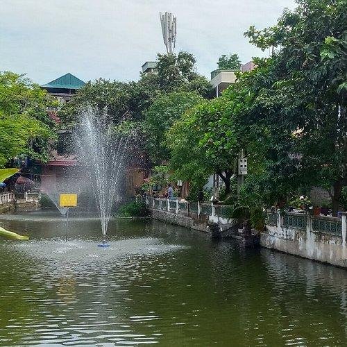 Local Vietnamese guide explaining historical significance of Hanoi landmarks to tourists