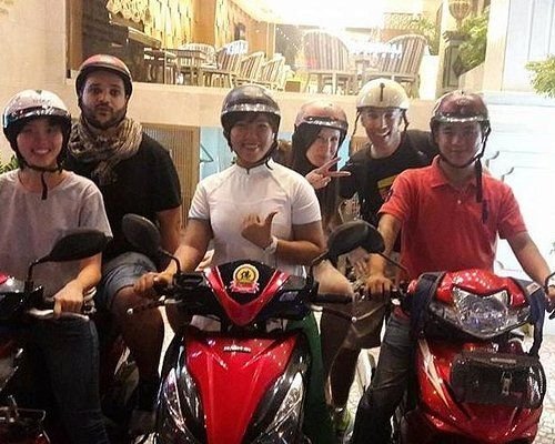 Tourists on motorbikes exploring Hanoi food scene