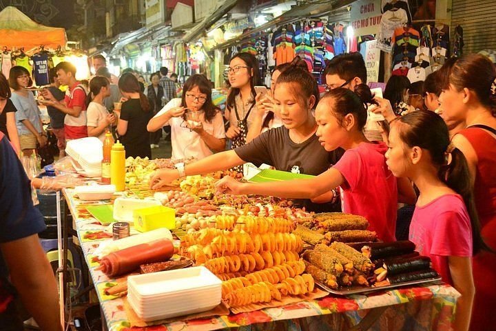 Hanoi night street food market with colorful stalls and vendors