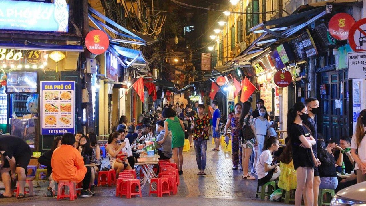 Vibrant food stalls in Hanoi Old Quarter with locals enjoying traditional dishes