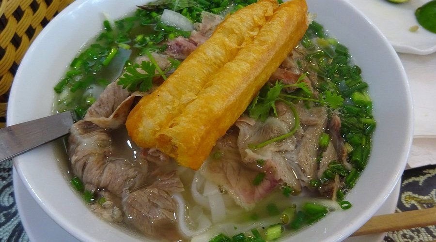 Steaming bowl of pho being served at Hanoi street stall