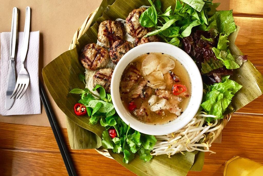 Traditional Bun Cha dish served with herbs and rice noodles