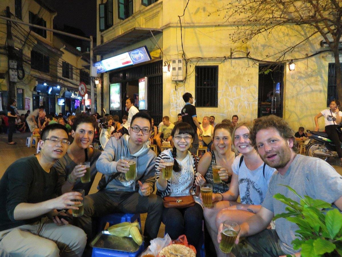 Tourist respectfully interacting with Hanoi street food vendor