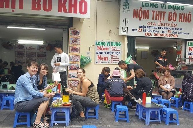 Bustling Hanoi street food scene with vendors and locals eating