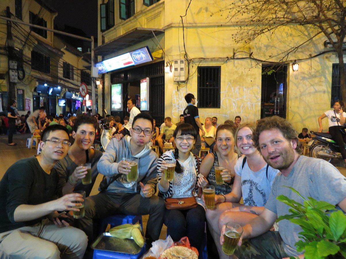 Busy Hanoi street food scene with multiple vendors serving customers