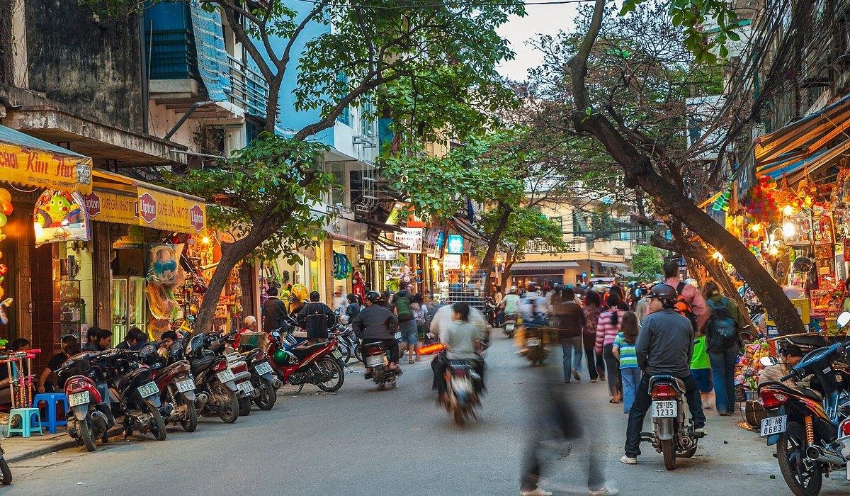 Typical street scene in Hanoi Old Quarter with vendors and motorbikes