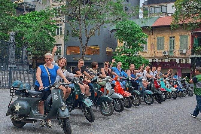Tourists enjoying food on a Vespa tour in Hanoi Old Quarter