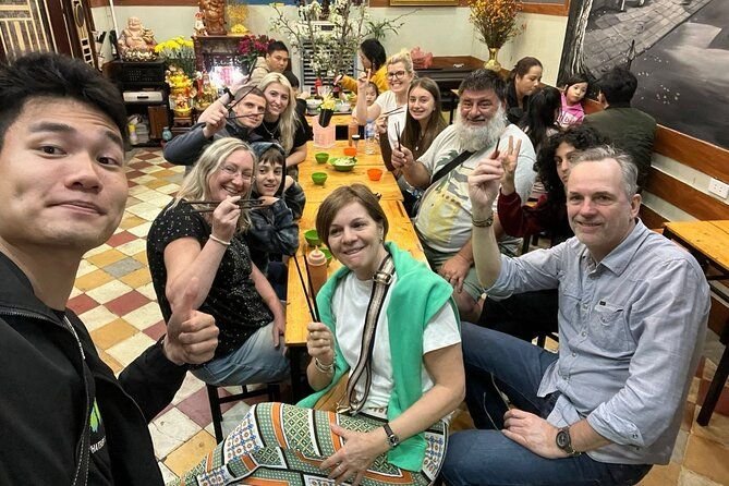 Group of tourists walking through Hanoi Old Quarter during guided food tour