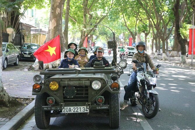 Vintage military jeep navigating through busy Hanoi streets during food tour