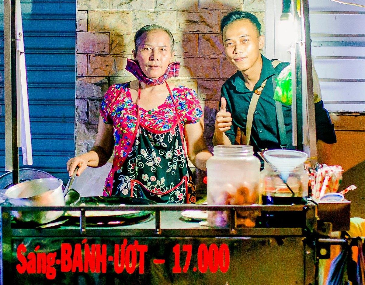 Local street food vendor preparing traditional Vietnamese dishes