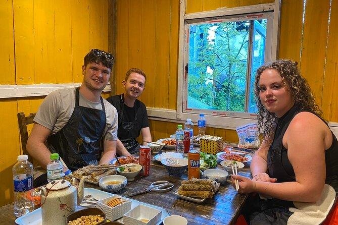 Tourists learning to make Vietnamese spring rolls in small group cooking session