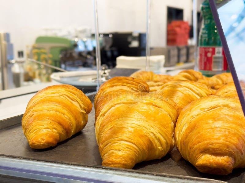 Golden croissants and pastries displayed in glass case at Paris Deli Hanoi