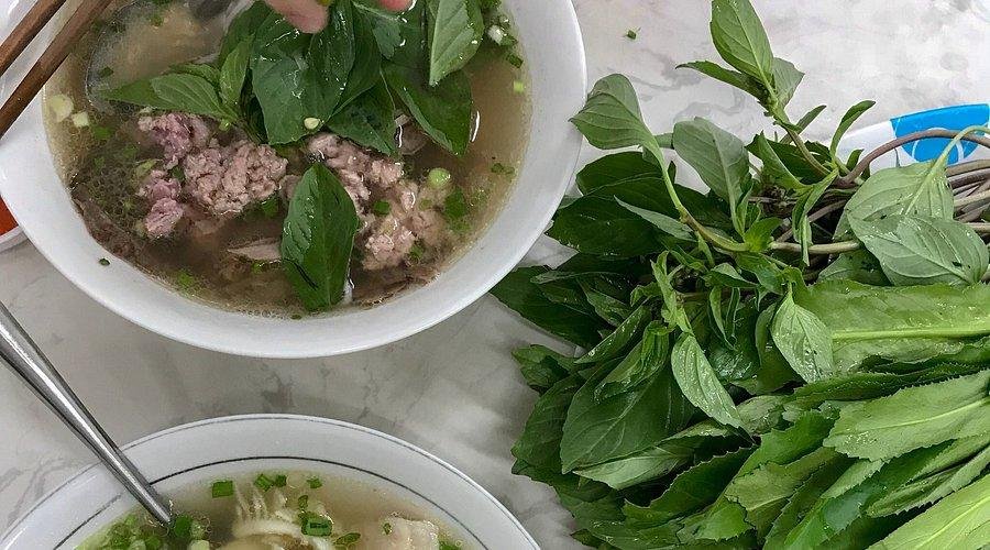Bowl of steaming phở with herbs and lime in Hanoi