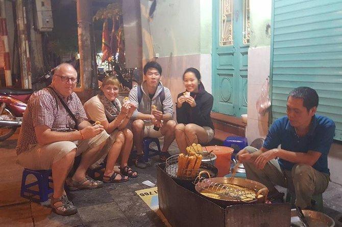Small group enjoying authentic Vietnamese street food in Hanoi's Old Quarter