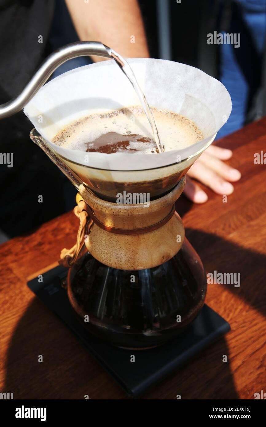 Professional barista preparing pour-over coffee at specialty shop