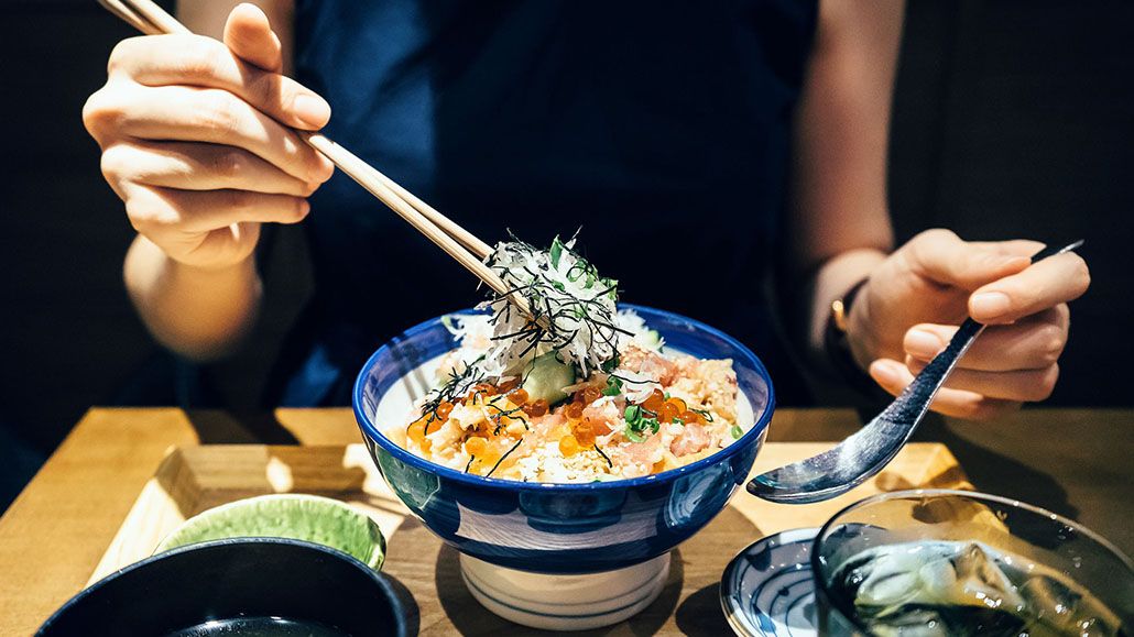 Tourists learning proper chopstick technique from Vietnamese guide