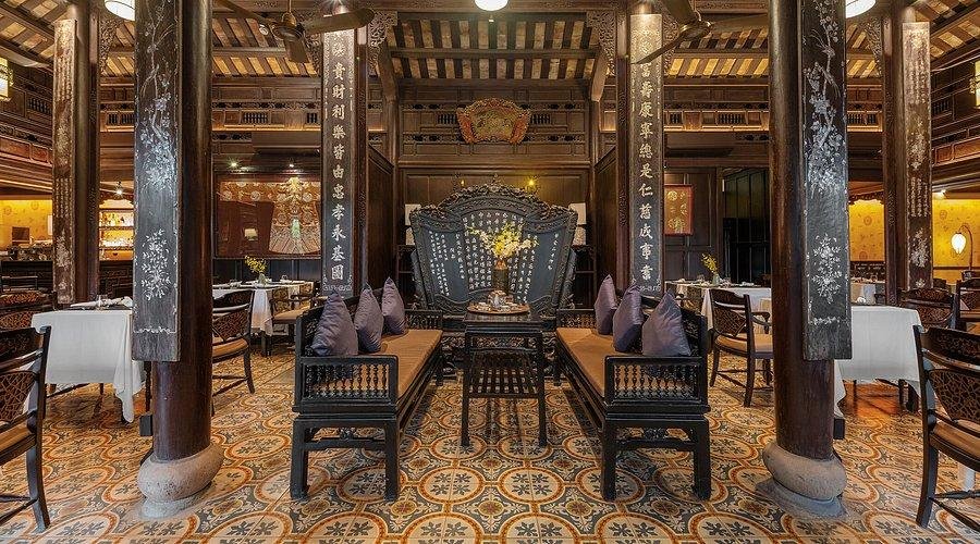 Interior of a traditional Vietnamese cafe with wooden furniture and locals enjoying coffee