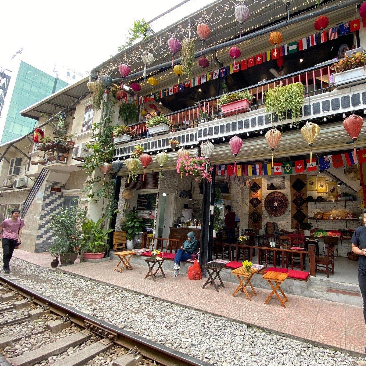 Tourist taking photos of train passing through cafe area