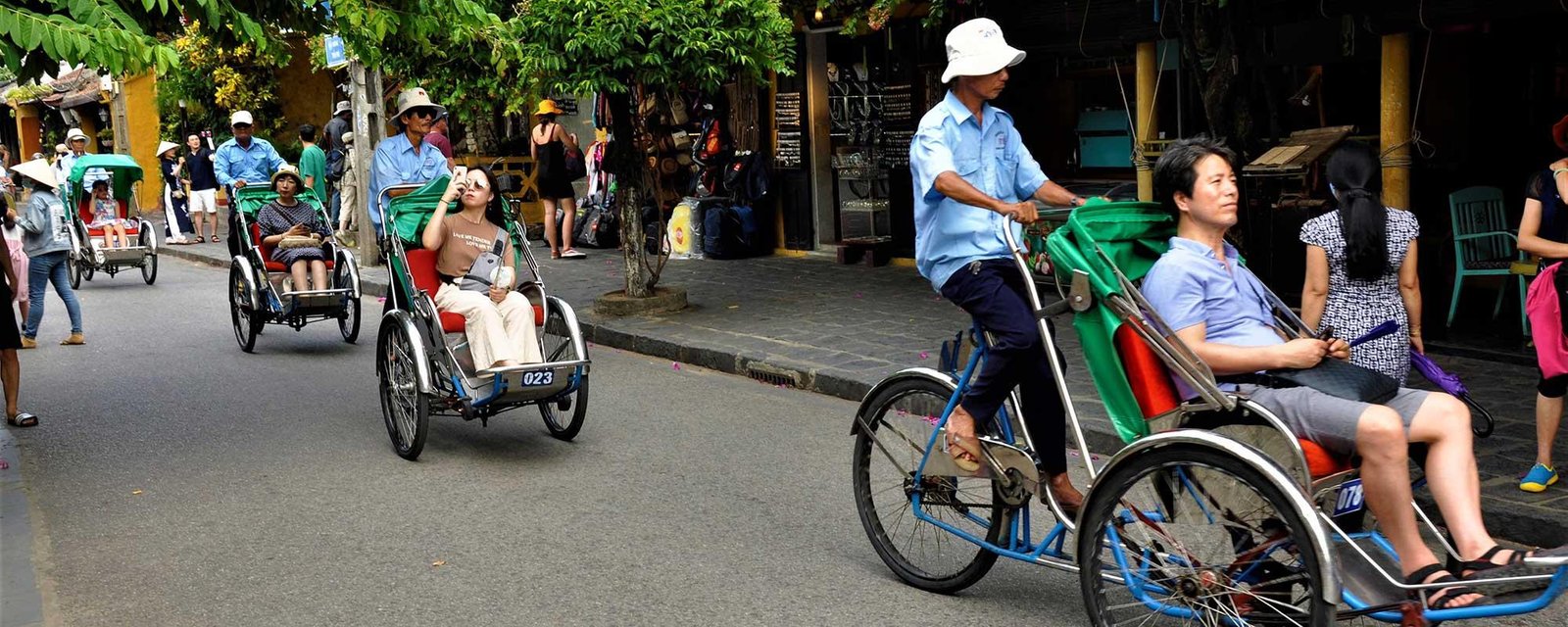 Traditional cyclo and modern taxi in front of French Quarter hotel