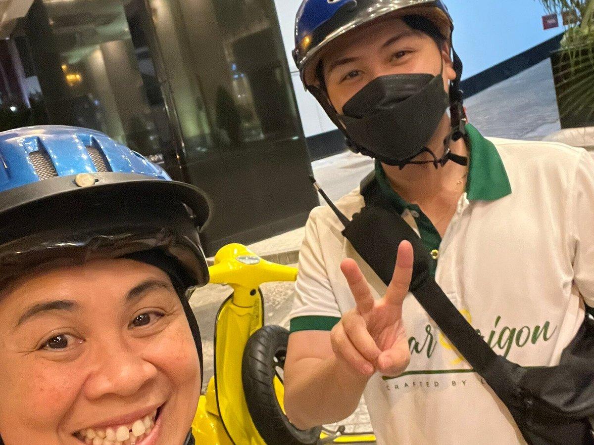 Tourist wearing safety helmet before starting vespa food tour