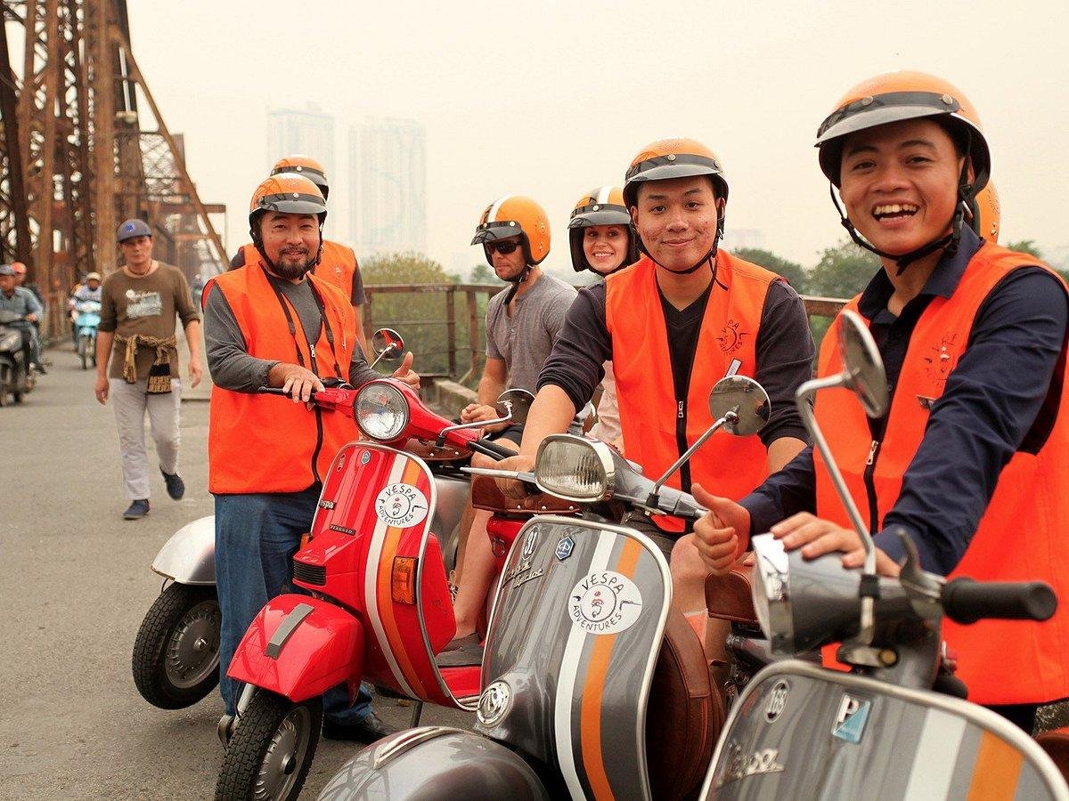 Tourist wearing helmet on Vespa tour in Hanoi