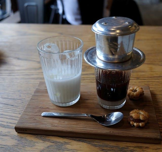 Traditional Vietnamese phin filter brewing coffee slowly into glass cup