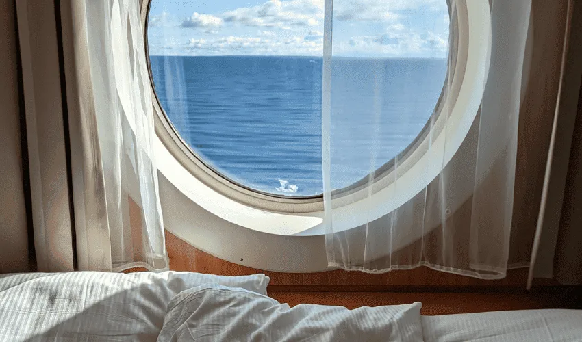 Luxury Mekong cruise cabin with a comfortable bed and panoramic river view