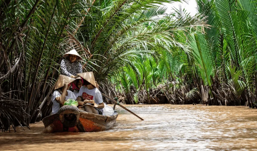 Travelers cruising through tropical waterways in the Mekong Delta Vietnam