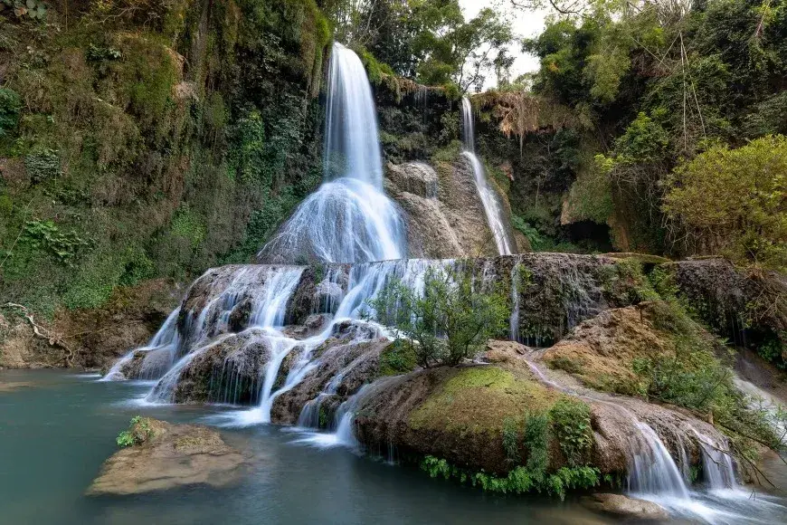 Multi-tiered Dai Yem Waterfall surrounded by green forest in Moc Chau